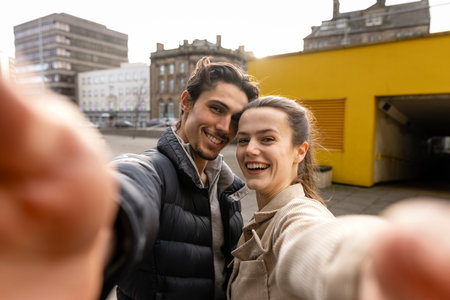 A front-view shot of a young couple standing together taking a selfie, they are in love.の写真素材