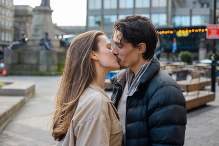 A side-view shot of a young couple standing together sharing a kiss, they are in love.の写真素材
