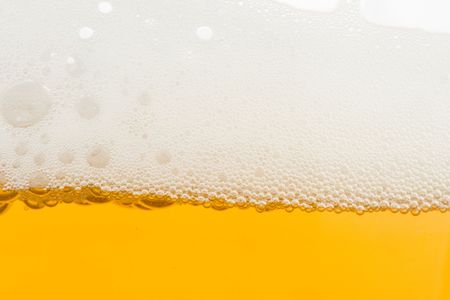 Background from fresh foamy beer with bubbles. Close-up.