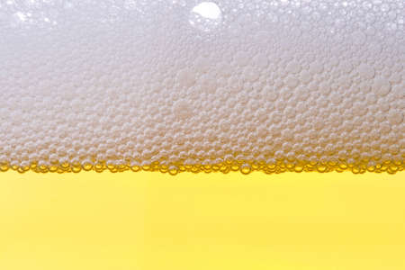 Background from fresh foamy beer with bubbles. Close-up.の写真素材