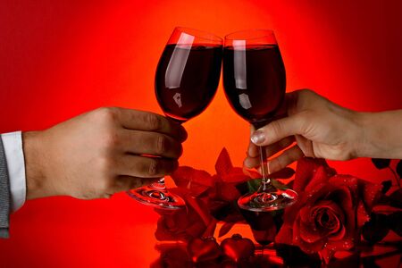 Two glasses of wine, rose and heart on a red background. Valentines day card.の写真素材