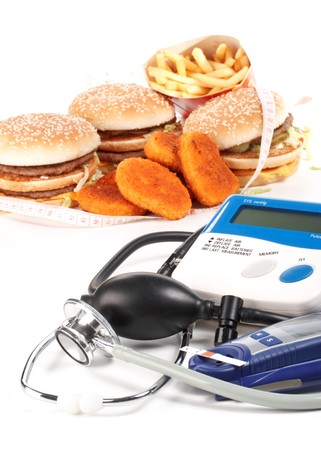 Fast-food, blood pressure meter, stethoscope and glucose meter on a white backgroundの写真素材