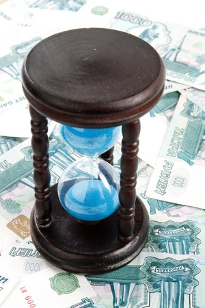 Hourglass standing on a floor from banknotes. Concept for time is money.