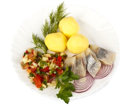 Dish with a herring, a potato, vegetables and greens on a white backgroundの写真素材