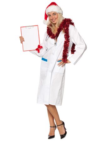 Young woman in a medical uniform and santa's hat holds blank clipboard in handsの写真素材