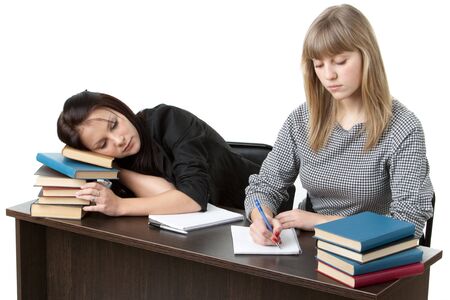 Two girlfriends of the student prepare for examination, sitting at a desk on a white background.の写真素材