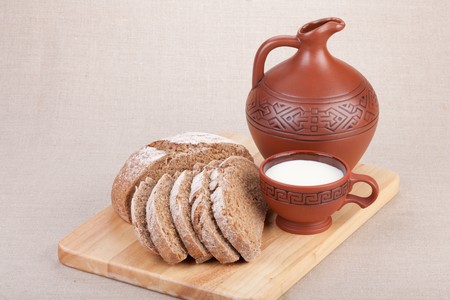 Morning still-life with a jug, a cup of milk and bread.の写真素材