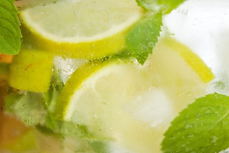 Background from mojito cocktail with lime, leaves of mint and pieces of iceの写真素材