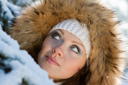 The beautiful young woman in winter snow-covered wood.の写真素材