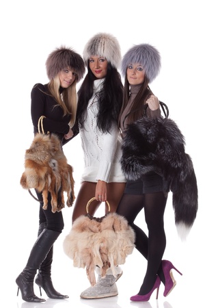 Young women in fur with bags  on a white background.の写真素材