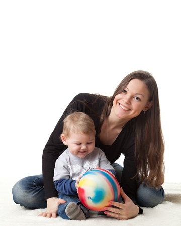 Young mother plays with her baby on a white background. Happy family.の写真素材