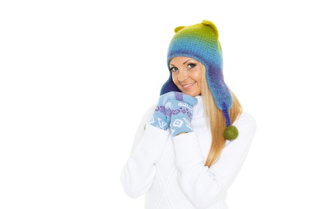 Young happy beautiful woman in winter clothes stands on a white background.の写真素材