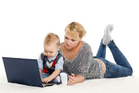 Young mother and her little son with notebook sit on a white background. Happy family.の写真素材