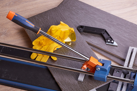Manual cutter  and ceramic tiles for floor. Home repair.