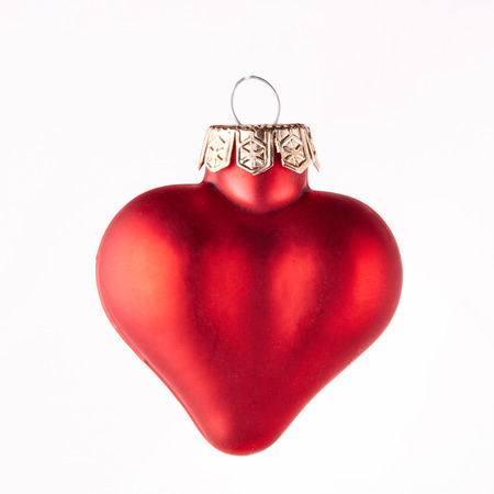 Glass toy red heart for decoration of a Christmas and New Year fir tree on a white background.の写真素材