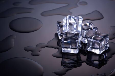 Ice cubes on a dark background with water drops. Melting ice.の写真素材