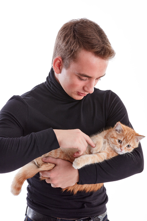 Young man with a small kitten on a white background.の写真素材