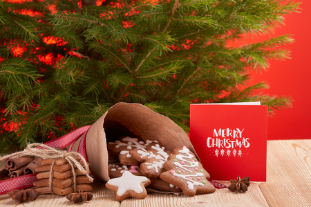 Christmas gingerbreads. Christmas decorations. Handmade cookies in paper cone  lying on the wooden table.  Christmas treats.の写真素材