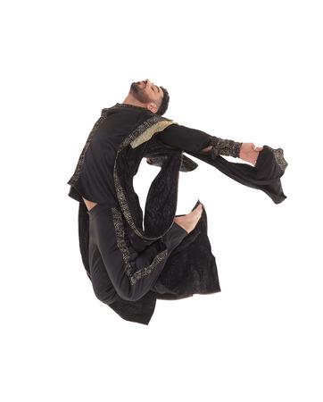Young strong man wearing  oriental costume dances on a white background.の写真素材