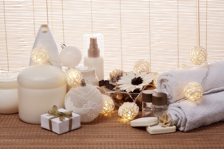 Spa still life with cosmetic creams,  towel, gift boxes and Christmas ornaments standing on bamboo mat. New Year and Christmas Healthy lifestyle, body care, Spa treatment and relaxation conceptの写真素材