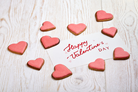 Cookies in the form of heart and greeting card  lying on a light wooden background. Valentine's Day card,の写真素材