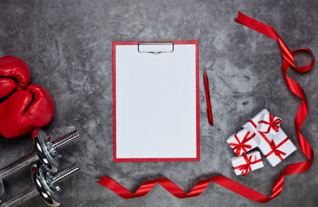 Dumbbells, boxing gloves, gift boxes and tablet with blank sheet on grey background.Top view. Valentine's Day card. Fitness, sport and healthy lifestyle concept.の写真素材