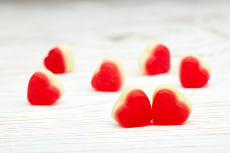 Sweet gummies in the form of heart on a light wooden background. Valentine's Day card, Design element for romantic greeting card, wedding invitationの写真素材