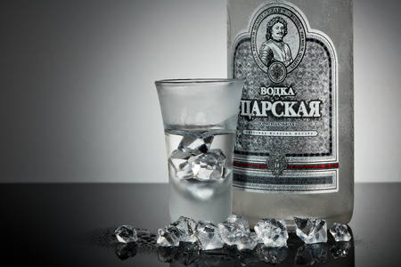 St.Petersburg, Russia - December 2018 - Bottle of cold vodka Czar's with ices and shot glass on a grey background with reflection. Premium vodka.  Produced in Russia. Original russian recipeのeditorial素材