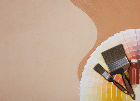 Color palette guide, paint brushes and bottle of paint lying on textural double background consisting of two beige shades. Top view with copy space, Concept of construction or design officeの写真素材