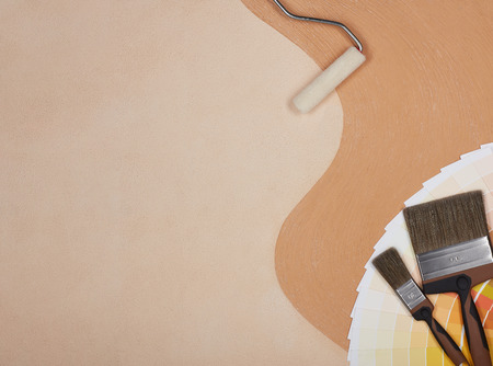 Color palette guide, paint brushes and roller lying on textural double background consisting of two...