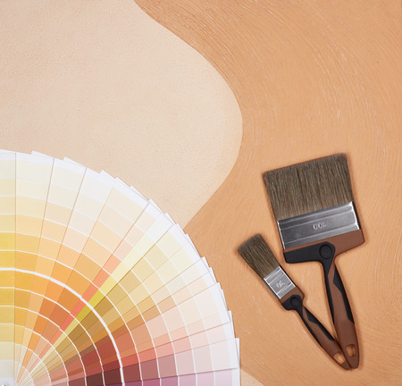 Color palette guide and painting accessories ( paint brushes) on textural double background consisting of two beige shades. Top view with copy space, Concept of construction or design officeの写真素材