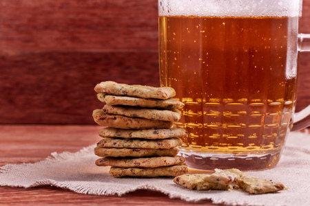 Still life of glass mug with light beer,  and cereal crispbread on a table on a wooden backgroundの写真素材