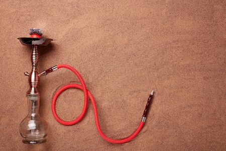 Turkish hookah (shisha) on a sand background.