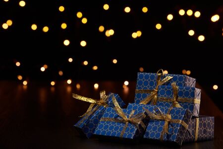 Gift boxes, Christmas decoration with LED lights garland on a black background with copy space. Christmas and New Year shopping. Greeting cardの写真素材