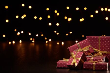 Gift boxes, Christmas decoration with LED lights garland on a black background with copy space....