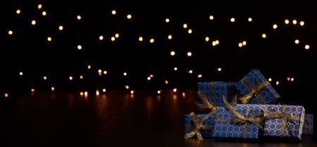 Gift boxes, Christmas decoration with LED lights garland on a black background with copy space....
