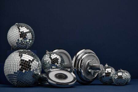 Dumbbell with weights and mirorr balls on dark blue background with copy space. For design of...