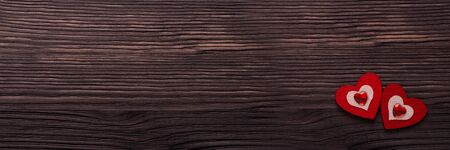Two decorative hearts on dark brown wooden background. Top view with copy space. Valentine's Day....