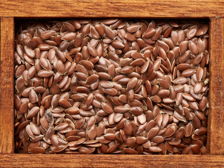 Flax seeds in wooden box on brown wood background. Top view. Healthy food. Vegetarian nutritionの写真素材