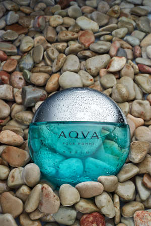 St.Petersburg, Russia - March 2020 - Bottle of cologne Aqva Pour Hoome Marine Bvlgari  on background from light pebbles with drops water.のeditorial素材