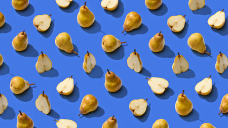 Food pattern background. Bright fruit pattern of fresh pears whole and sliced on blue background. Top viewの写真素材
