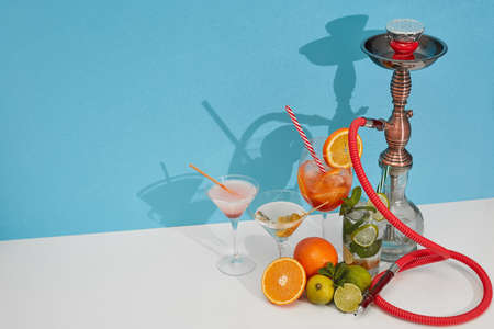 Cocktails set. Hookah (shisha) and glasses with various cold  beverages standing on double white...