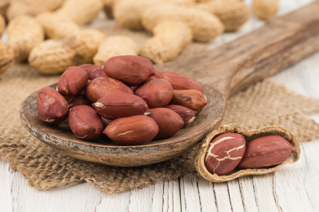 Peanut closeup on a wooden spoon and a wooden table. Selective focus.の写真素材