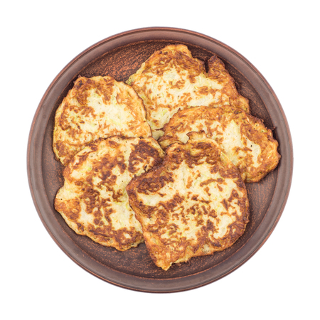 Pancakes with zucchini on a plate. Isolated on white. Tpo view.の写真素材