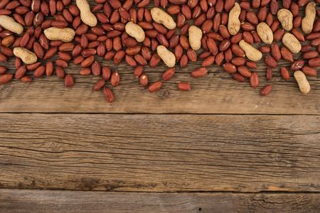 Peanuts on the background of the old wooden table. Top view.