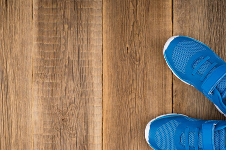 Blue Sneakers with wooden backgroundの写真素材