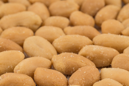Salted peanuts on white old wooden table. Selective focus.
