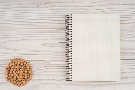 Chickpeas with a notebook on an old white table. Top view.の写真素材