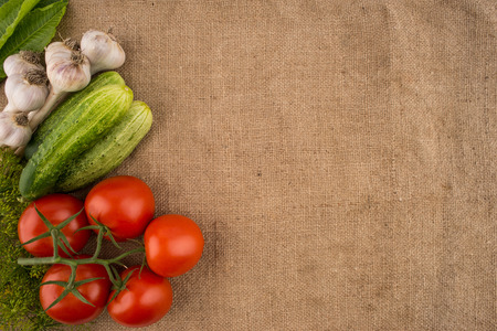 Cucumbers, tomatoes, garlic and dill on the background of old sacking. Top view.の写真素材