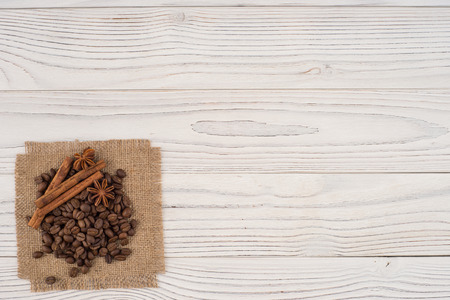 Coffee beans with cinnamon and star anise on an old wooden table. Top view.の写真素材